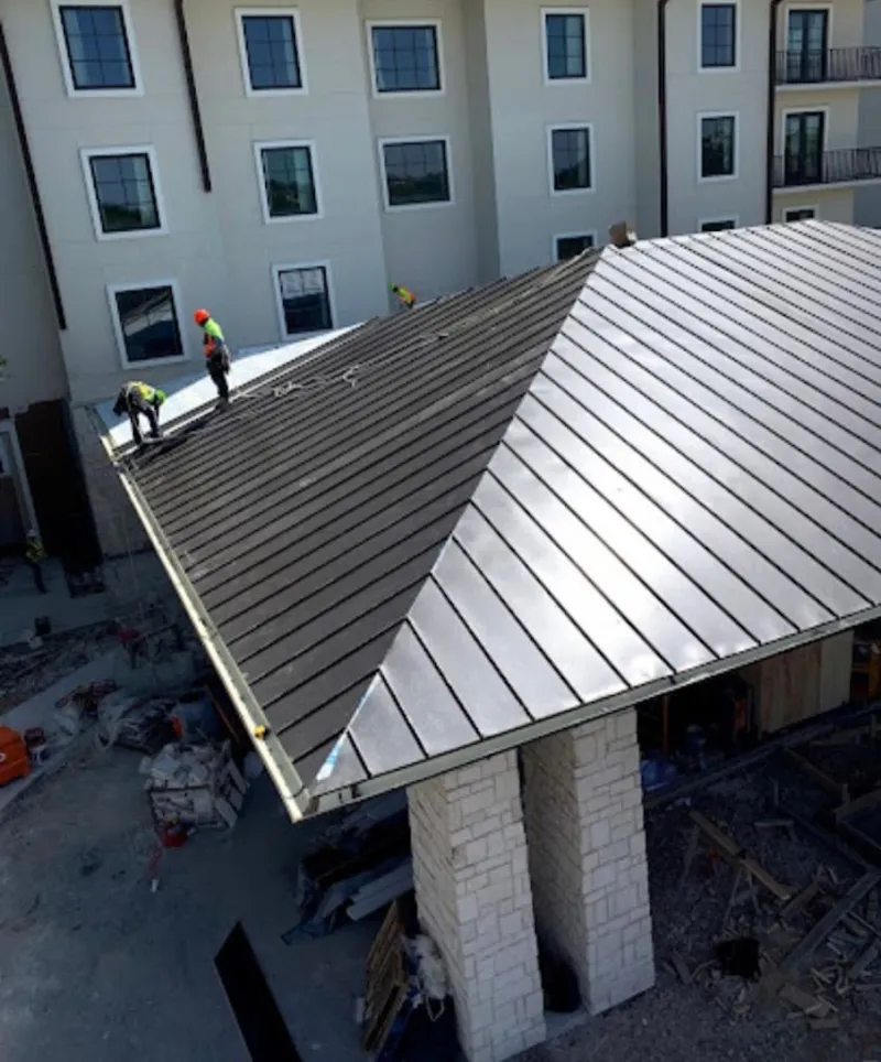 Crew installing standing seam metal roof panels on a commercial project in Fort Myers Beach